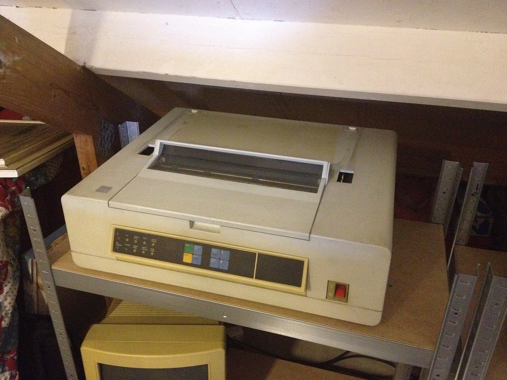 A daisy wheel printer with its cover open, showing the print mechanism and the daisy wheel character element.