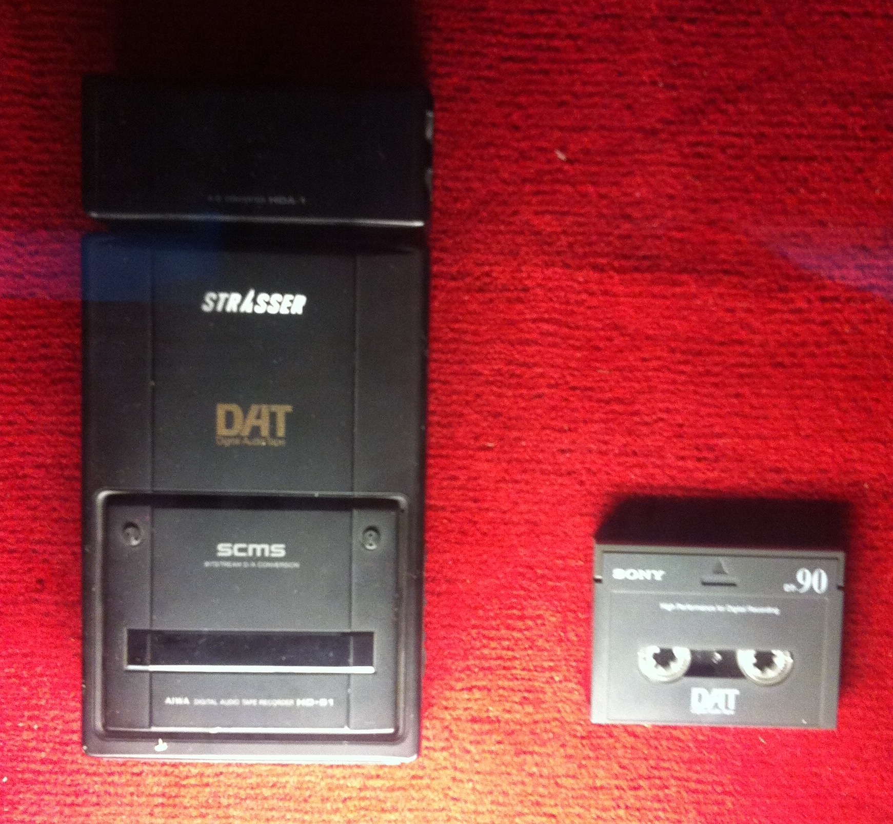 An Aiwa DAT recorder beside a Sony Digital Audio Tape cassette.