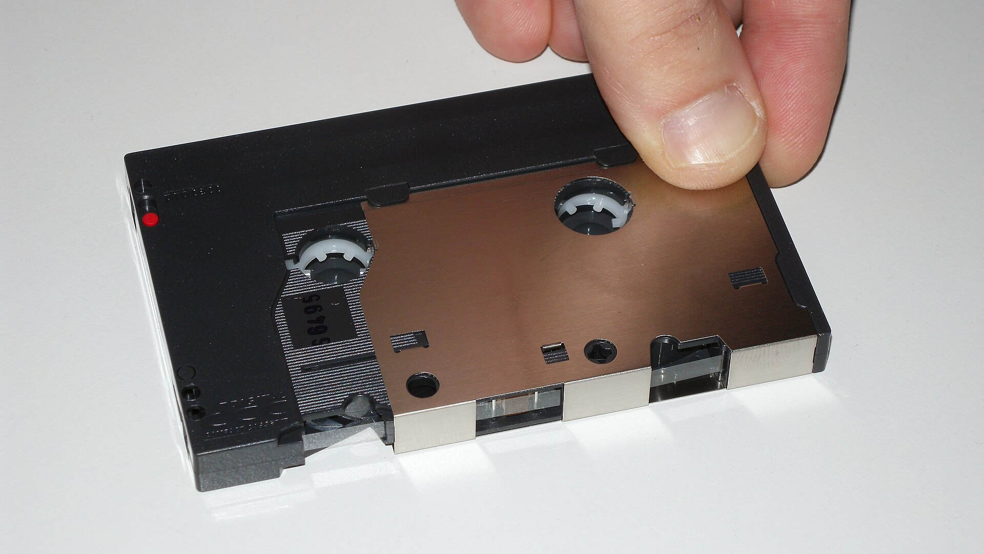 Philips Digital Compact Cassette with its protective cover opened, showing the tape