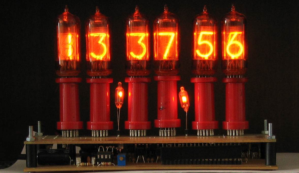 A Telefunken ZM1210 Nixie clock glowing orange, displaying the time 13:37