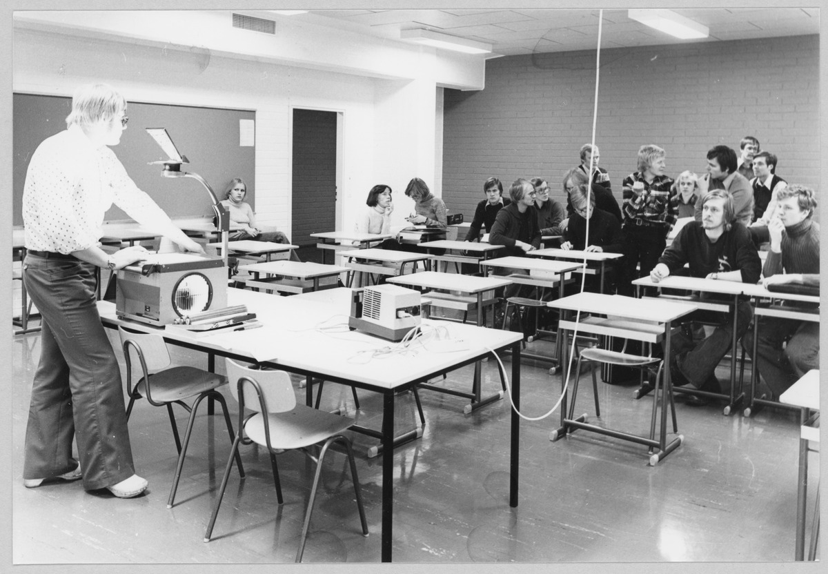 Teacher using an overhead projector in a university classroom, 1975