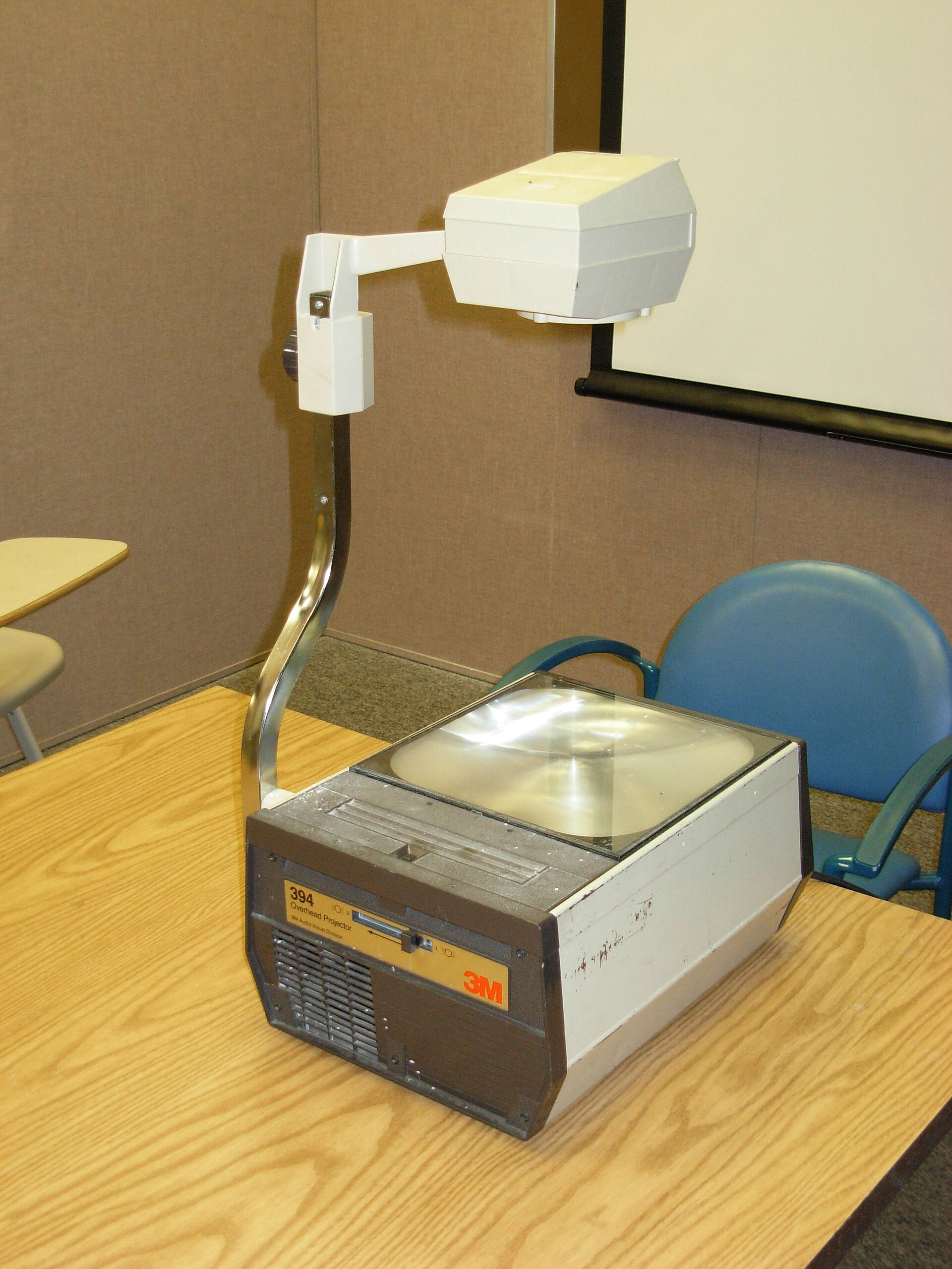 A 3M overhead projector showing the projection head, arm, and stage