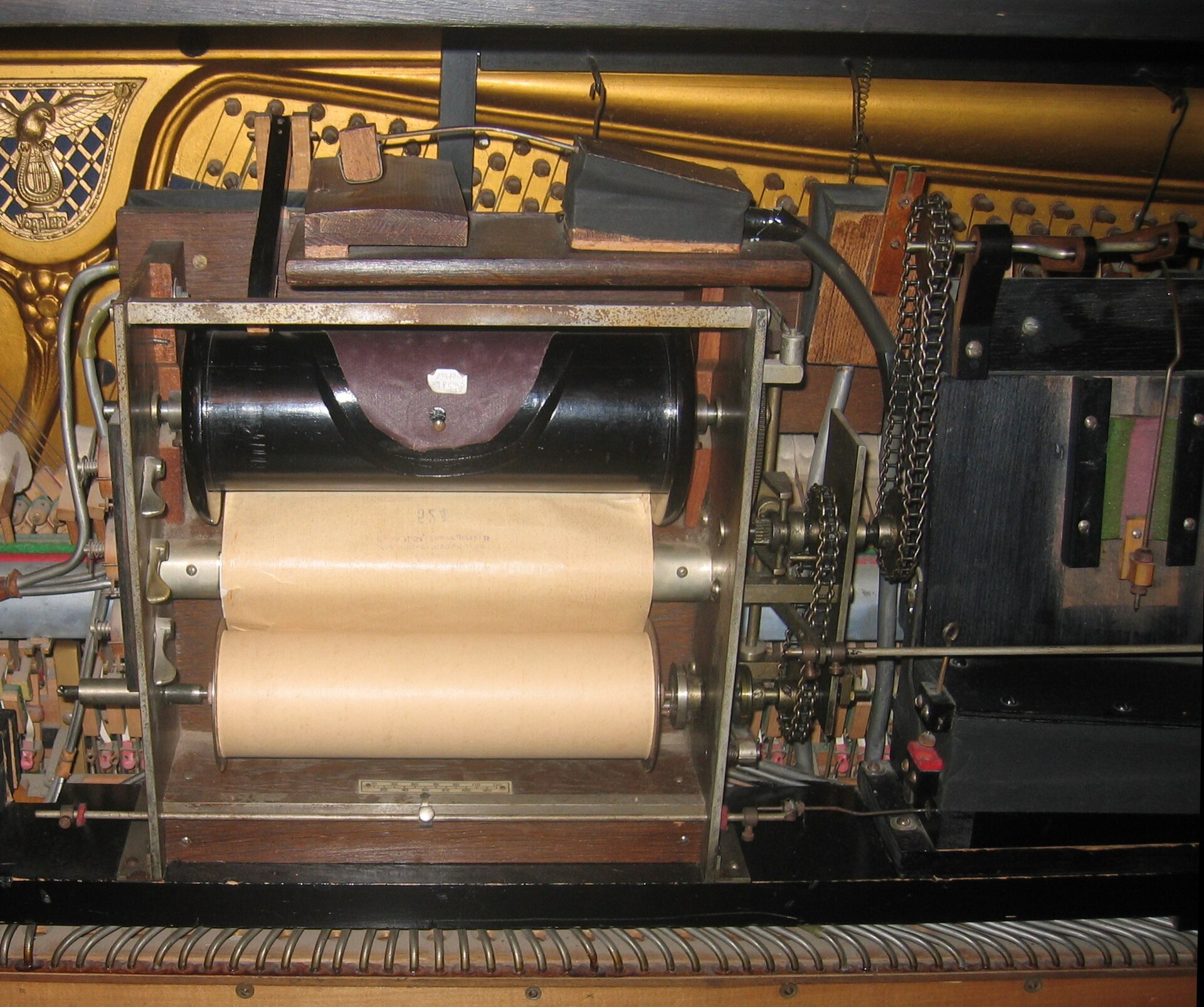 The internal mechanism of a player piano with a paper roll