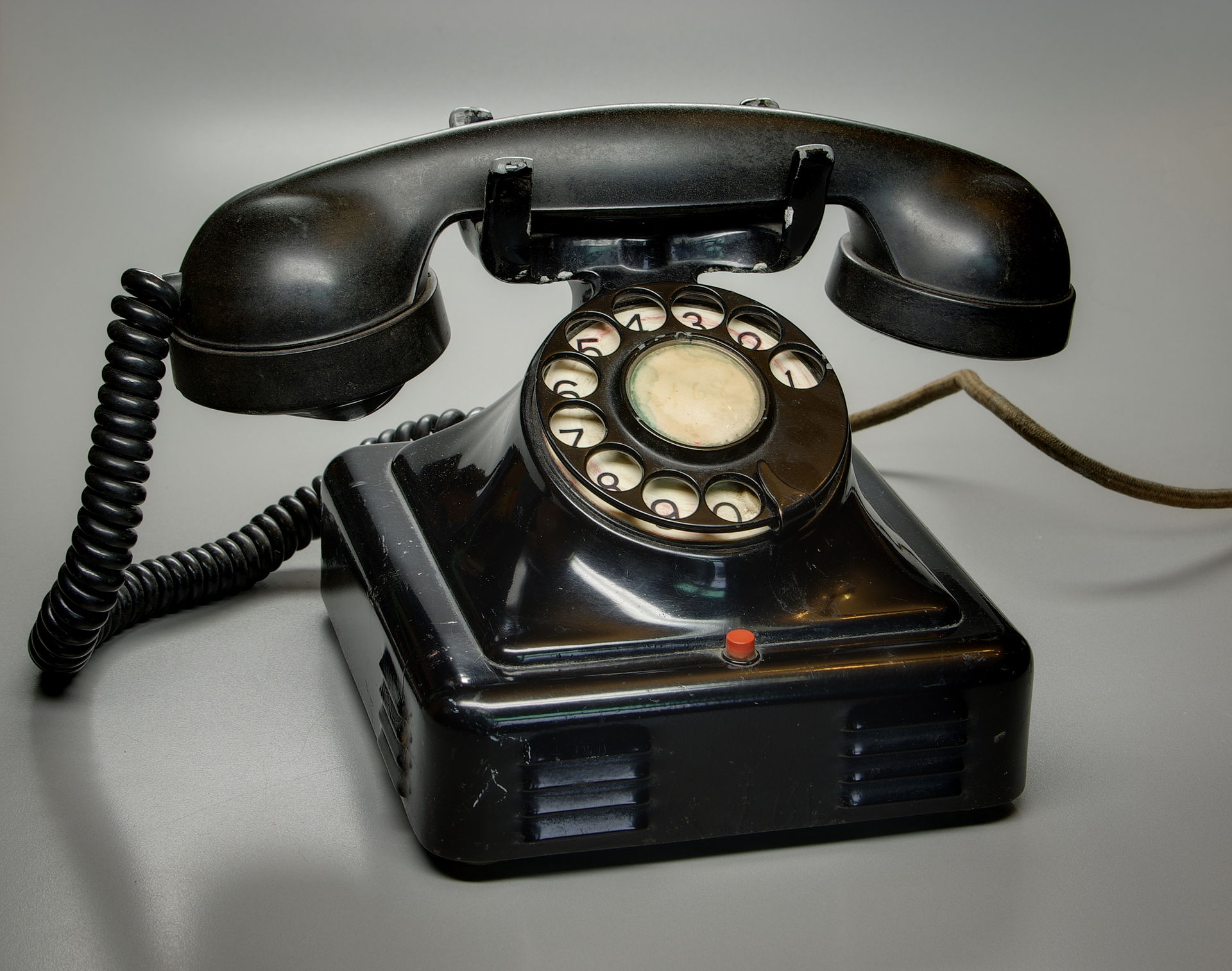 A black rotary-dial telephone with a handset and circular finger-wheel dial.
