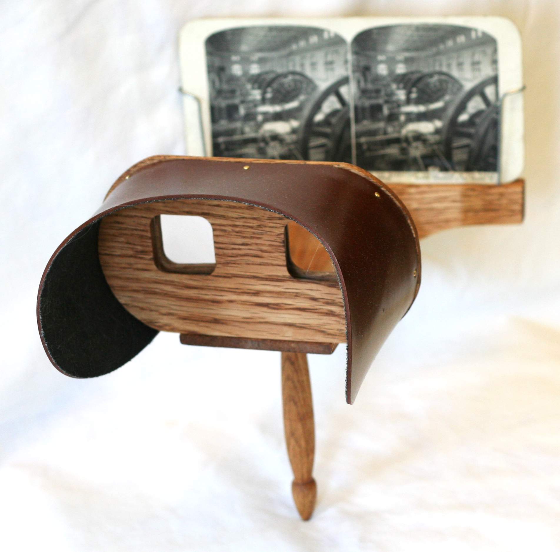A Holmes-type stereoscope: an open-frame handheld viewer with twin lenses and a sliding holder for a stereograph card