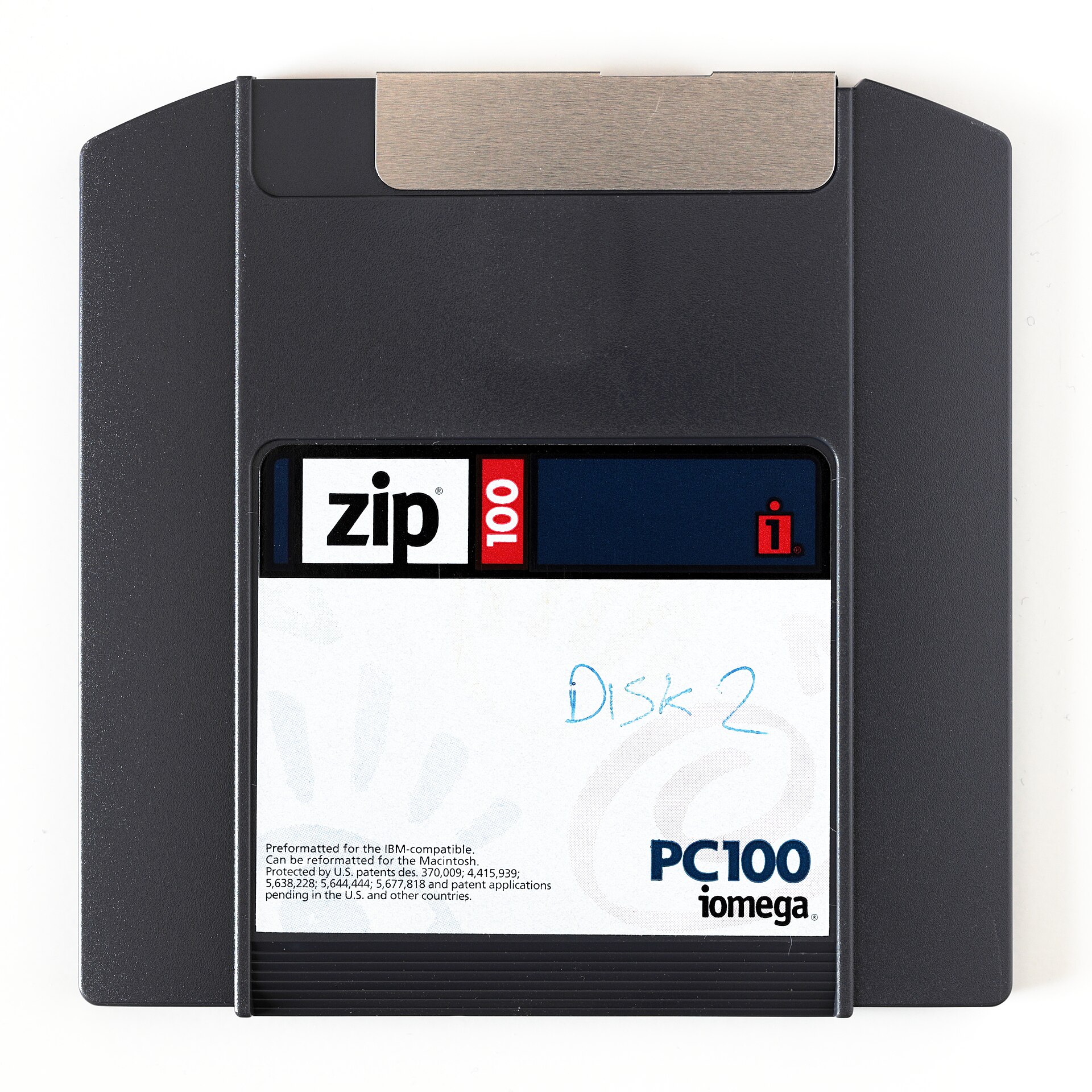 An Iomega 100 MB Zip disk, the teal-and-grey removable storage cartridge of the late 1990s.