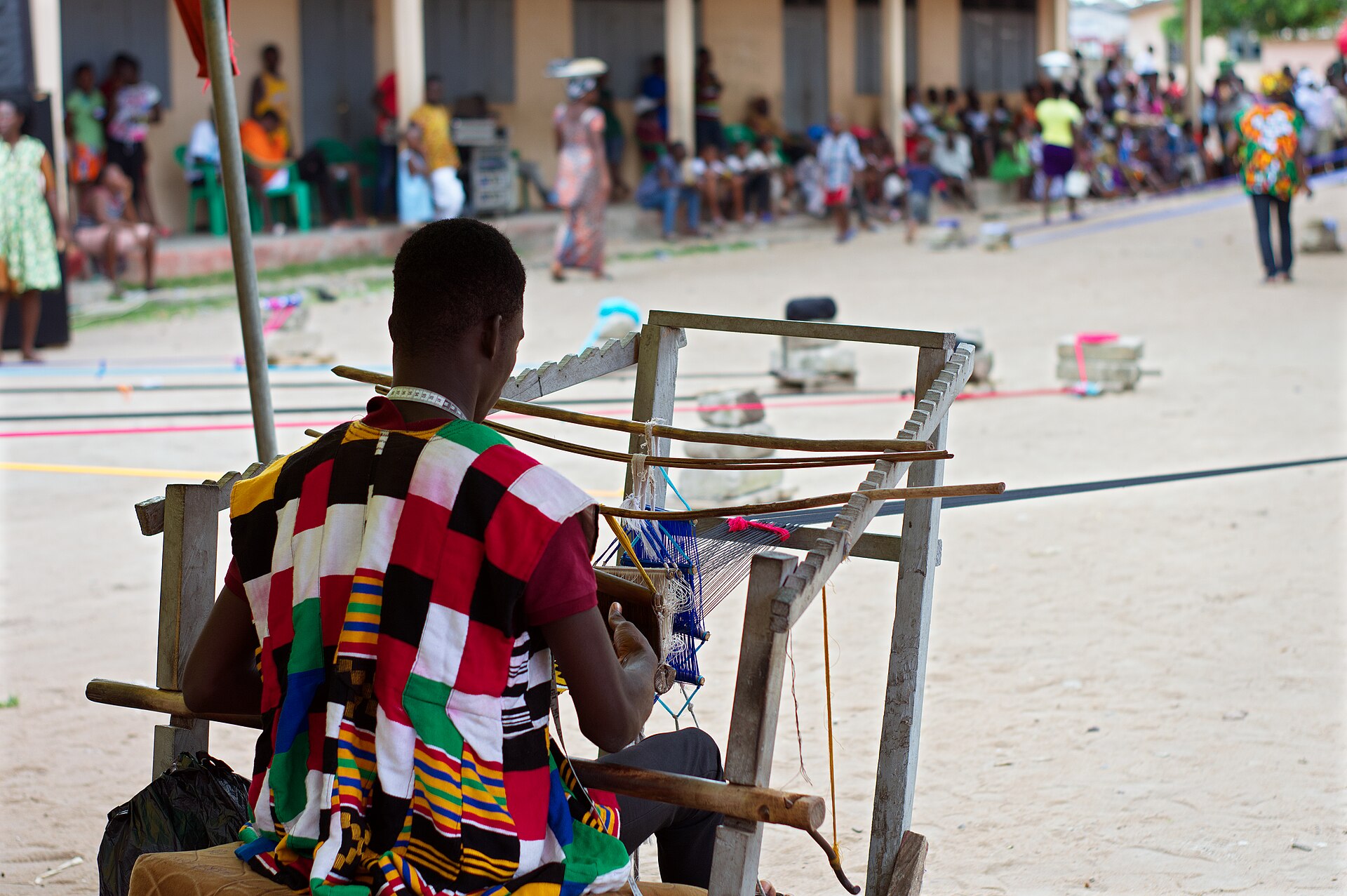 A weaver making kente cloth on a traditional loom, the prestige textile of the Asante court