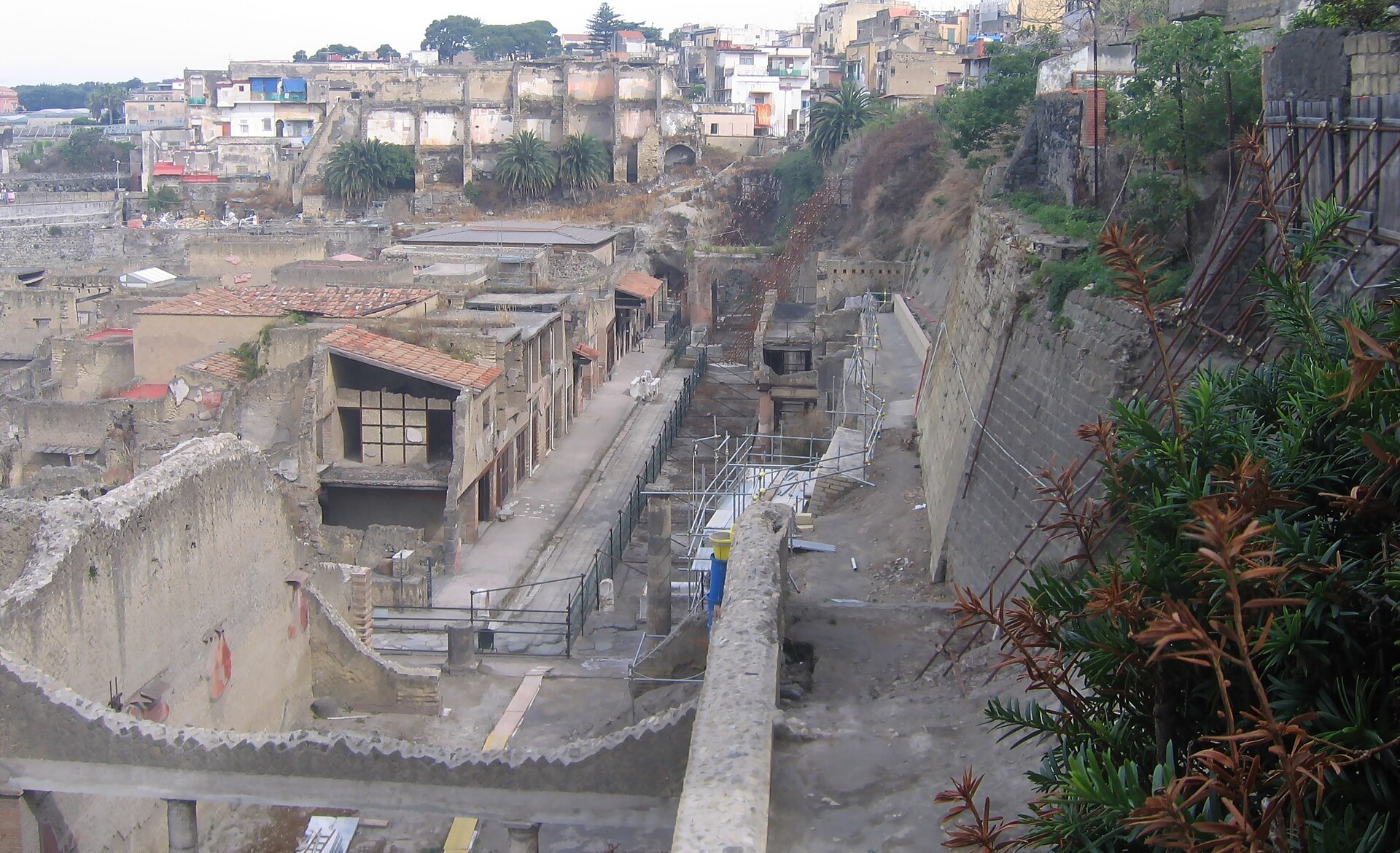 The excavated archaeological area of Herculaneum, its roofless Roman buildings sunk below the modern town of Ercolano.